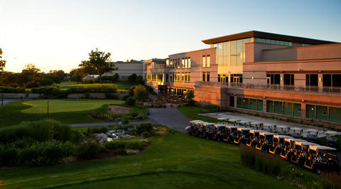 Exterior of golf club house with golf carts parked outside