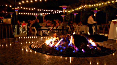 Outdoor restaurant seating area with flaming fire pit