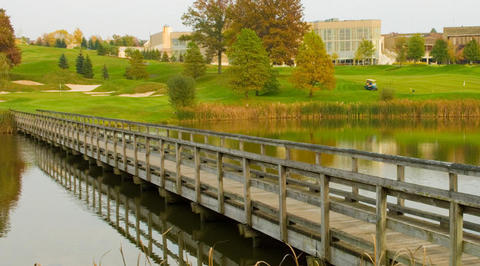 Bridge crossing over lake with golf course in background